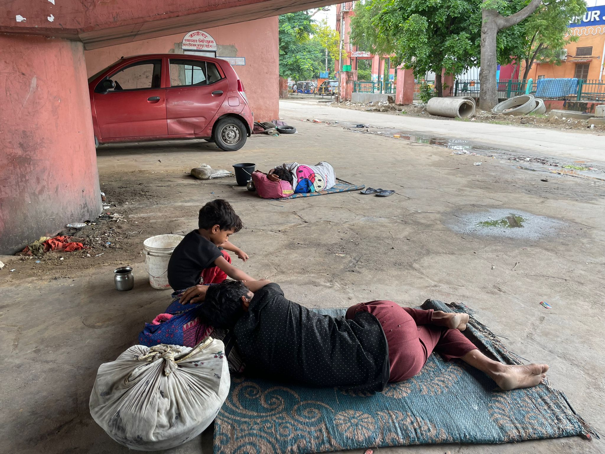 Street boy next to his dad sleeping on the floor